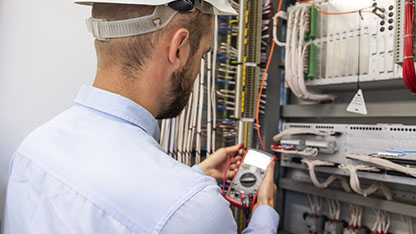 Young adult electrician builder engineer inspecting electric equ Young adult electrician builder engineer